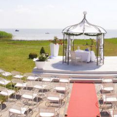 Inselhof VINETA - Blick durch den Rosenbogen auf den Hochzeitspavillon mit dem Achterwasser im Hintergrund
